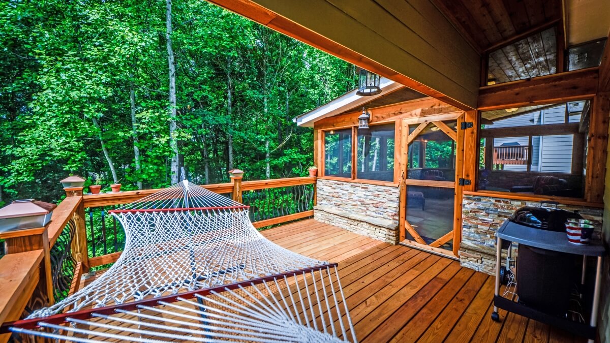 screened-in back porch with hammock on wood deck