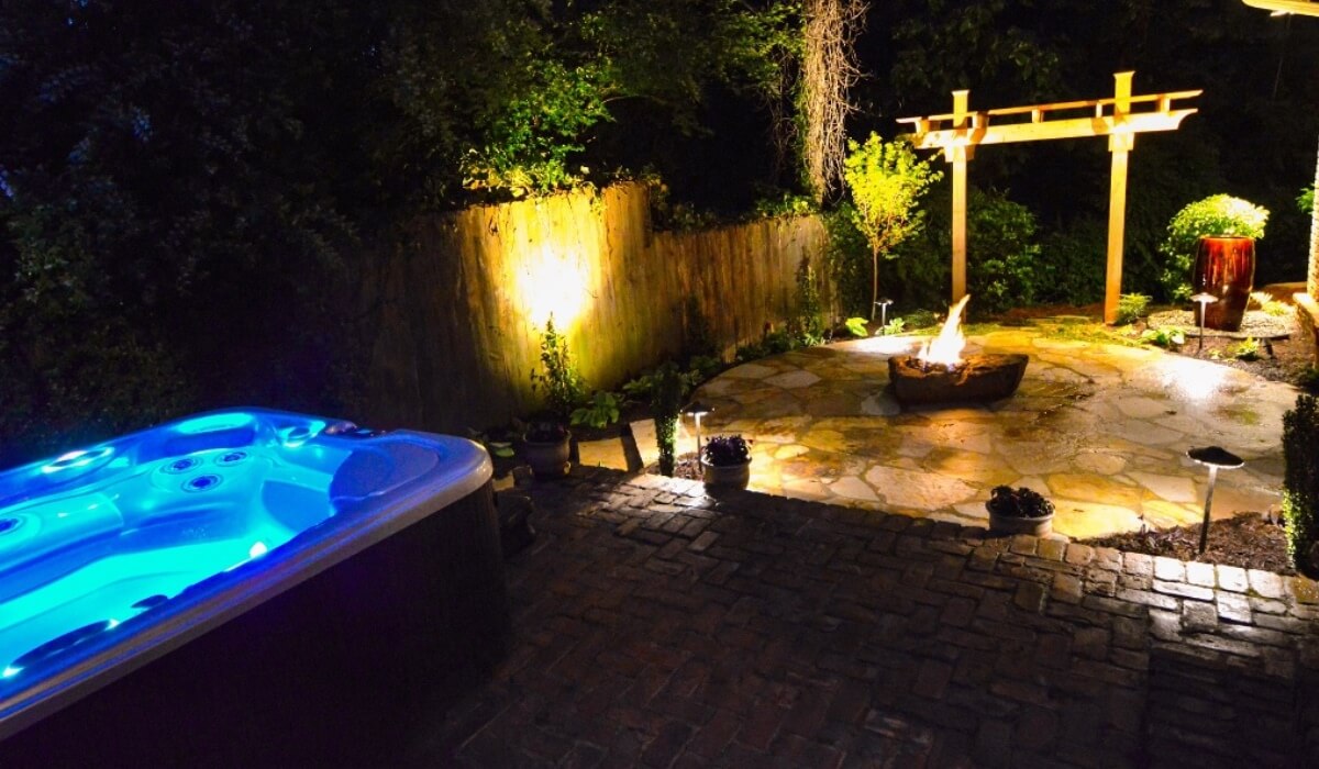 Outdoor makeover: Backyard living space with fire pit, patio, hot tub, and lighting