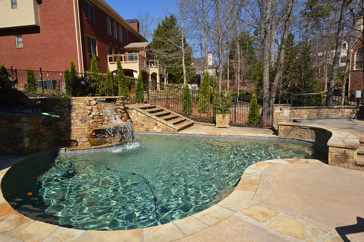 backyard stone pool with water fall feature