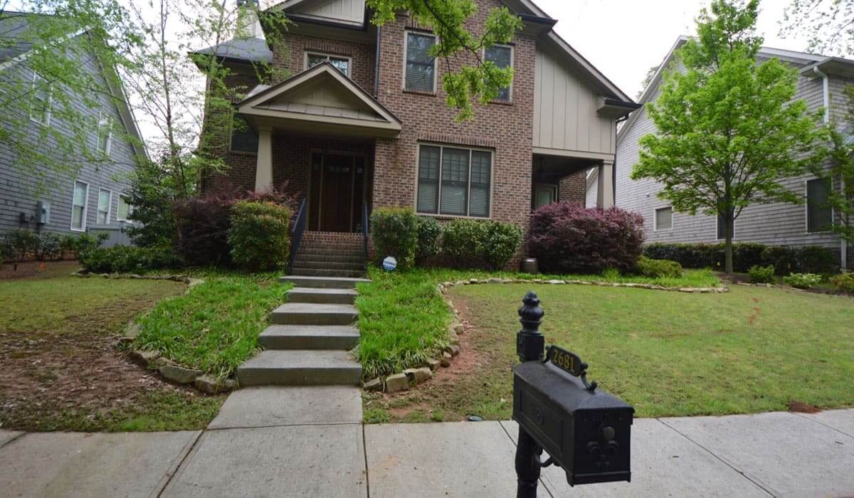 Outdoor makeover: brick house with concrete stair walkway and black mailbox in the front yard
