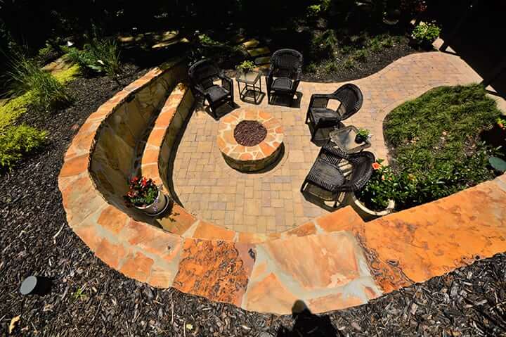 looking down on circular fire pit with hardscape design and outdoor furniture