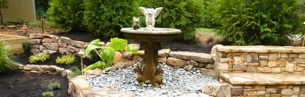 stone water fountain with landscaping and hardscaping design