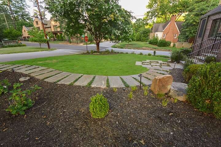 front yard stone landscape walkway leading from brick house to the street